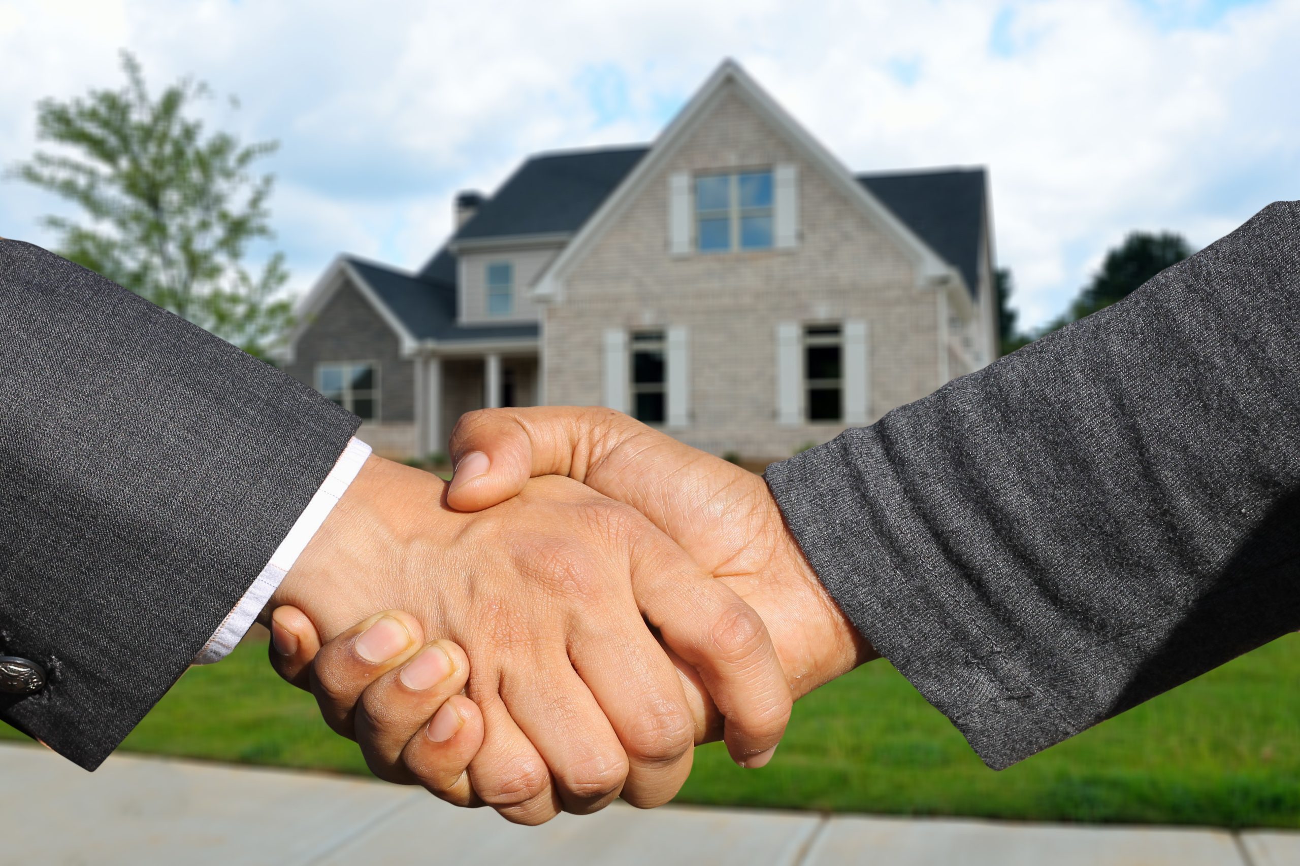 handshake with a house in the background